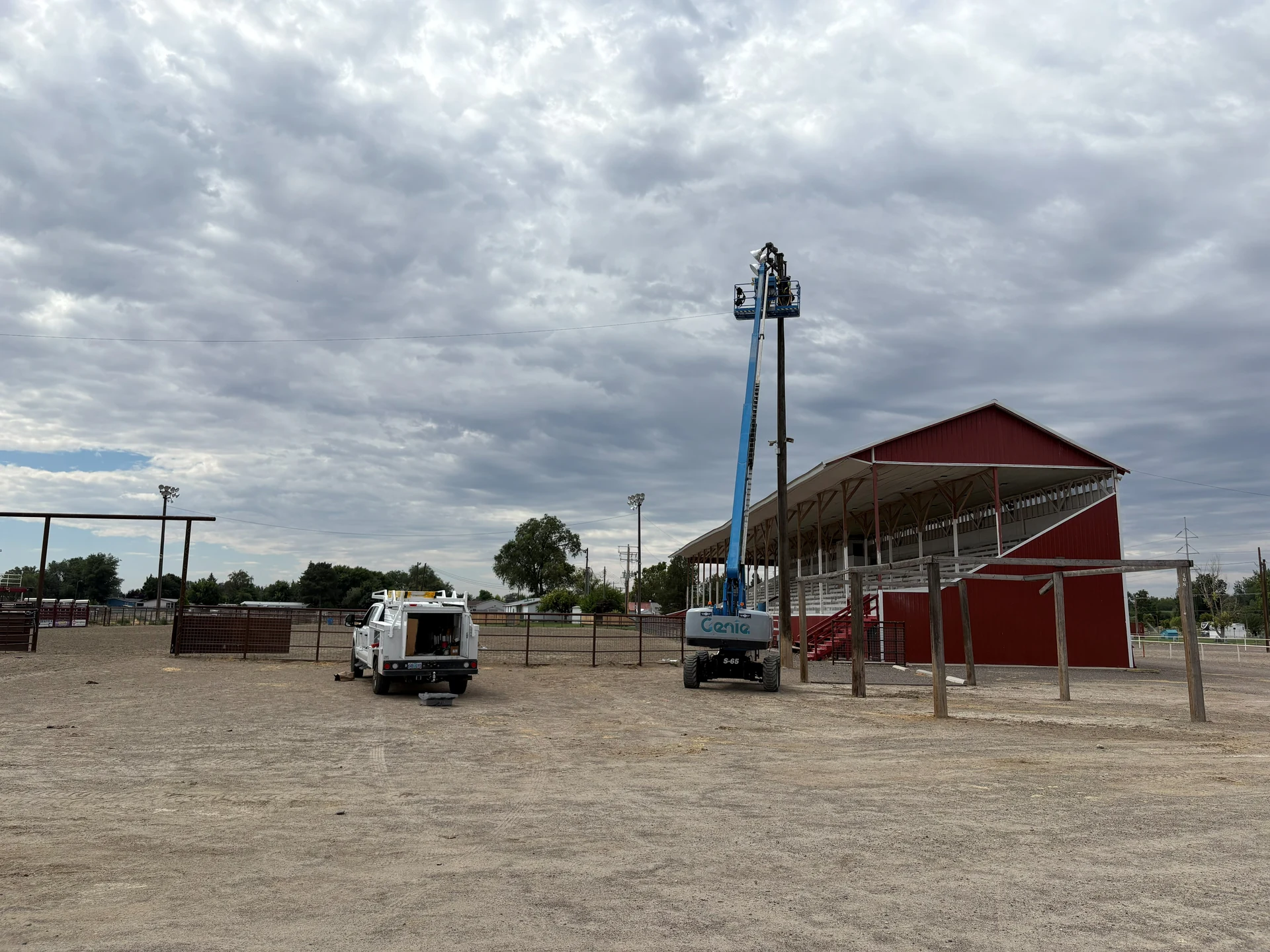 Commercial lighting installation service truck and boom lift at outdoor arena in Ontario, OR by Campbell Electric