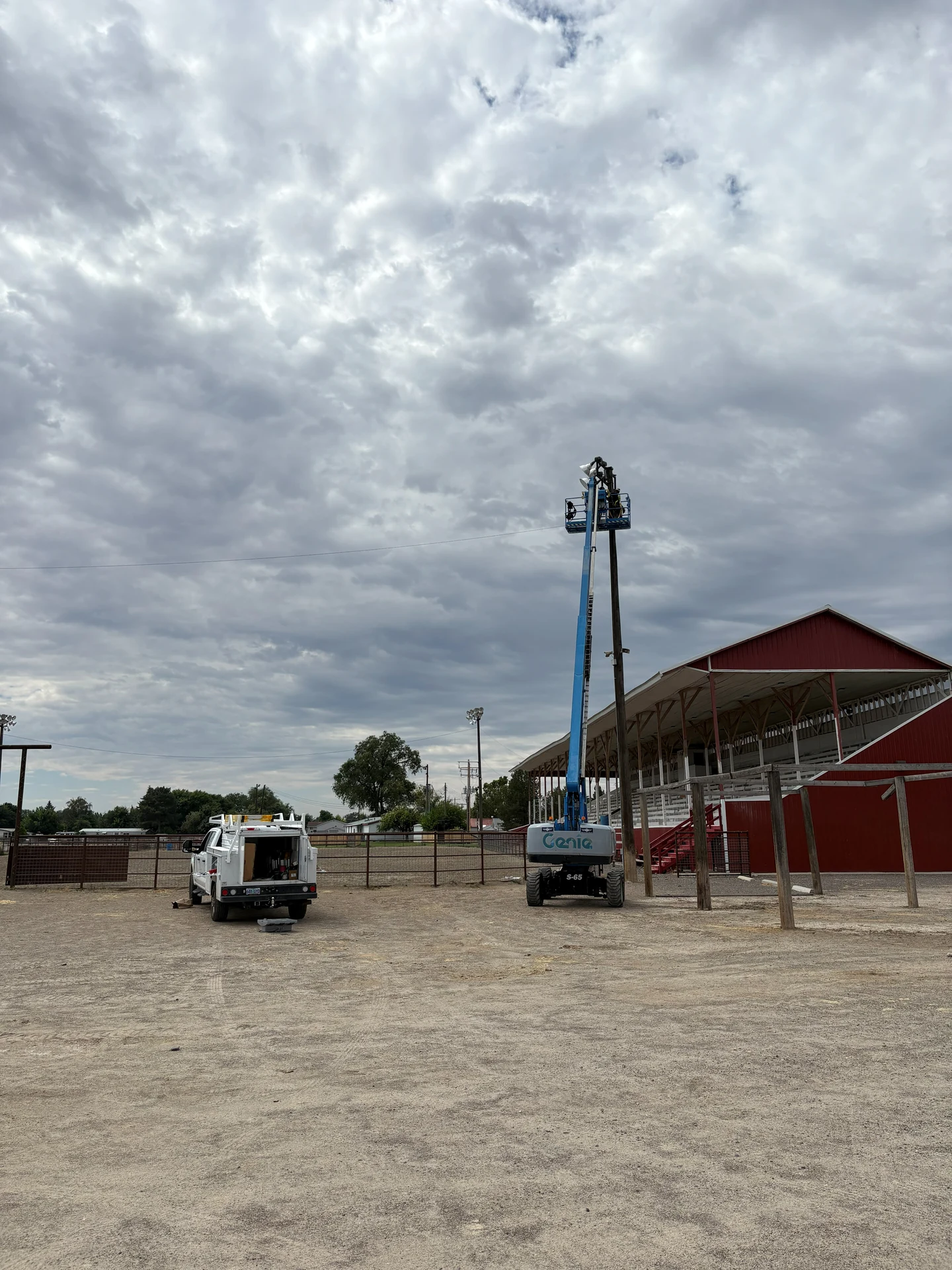 Electrician repairing high mast floodlights from boom lift at fairgrounds in Ontario, OR by Campbell Electric