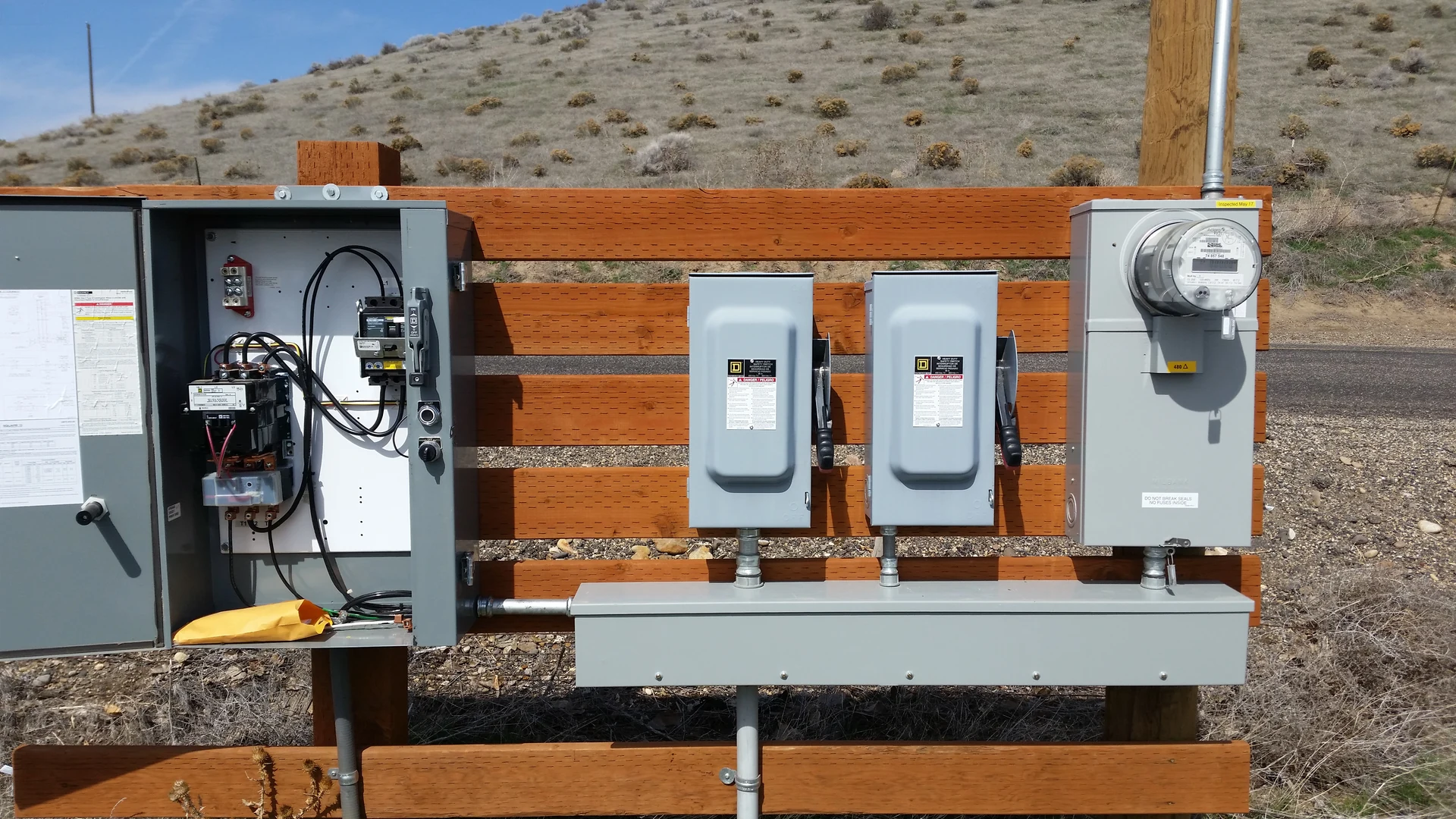 Outdoor electrical service panel disconnect switches and meter on farm fence in Ontario, OR by Campbell Electric